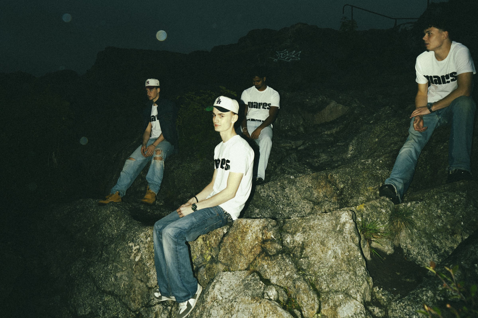 MARES crew in MARES logo t-shirts on the rocks at night